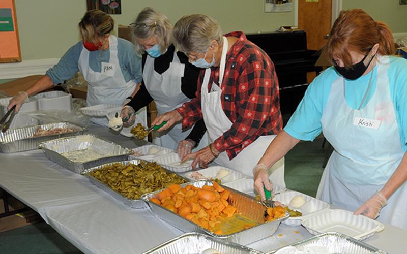 Pam Smith, Carolyn Howard, Sandy Daugherty and Kristi  Buchanan, from left, volunteered for the Good Samaritans's annual Open Table event, which was held Thanksgiving Day at the Fannin County Senior Center. This year the event had to be changed from the annual sit-down, festive occasion to a drive-thru offering. These volunteers were busy preparing plates for hungry participants.