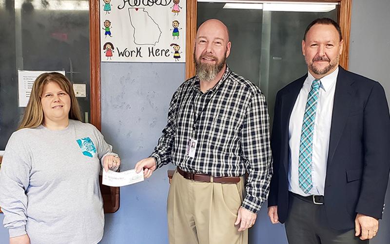 Fannin County Department of Family and Children Services (DFCS) Board of Directors Chairman James Jones presents a $4,500 check to Renee Bell, president of the Foster Parent Association, Wednesday, December 9. Beside Jones is Fannin DFCS Director Mark Knowles. The Association raises funds for foster children’s Christmas gifts, yearbooks, class rings, clothes, crutches and other things needed for the children.