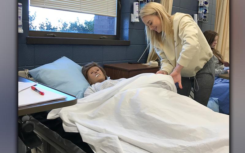 Fannin County High School student Mackenzie Johnson practices the skill of repositioning a dependent patient on their side in Healthcare Science teacher Anne Gibbs’ Patient Care Fundamentals course, which is one of the courses offered in the Healthcare pathway where students can gain state certifications.