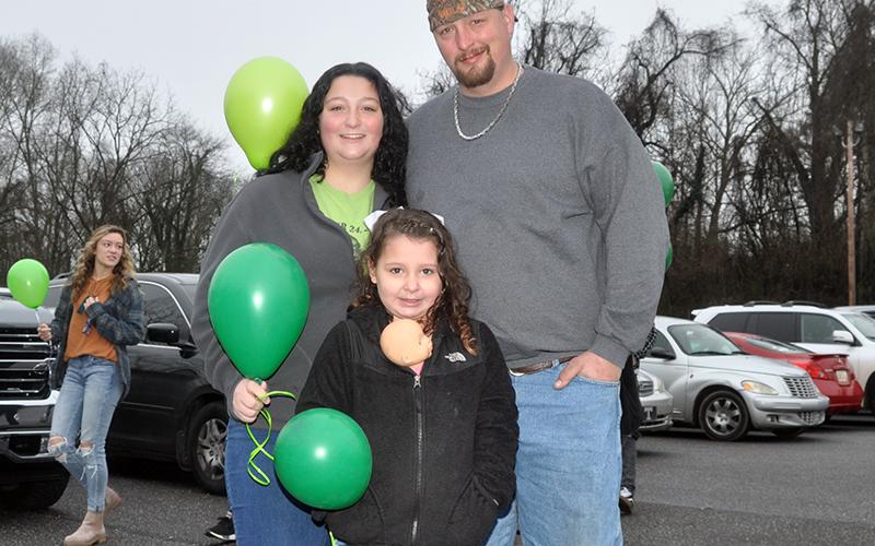 RIGHT: Bristol Cash waits patiently with her parents, Abby and Teddy Cash at the balloon release in the parking lot of First Baptist Church of Blue Ridge Friday, January 22.
