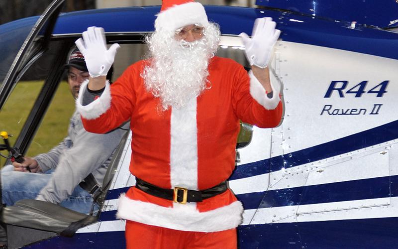 Santa Claus waves to everyone as he steps out of the helicopter that carried him to his visit at the Fannin County Recreation Center.