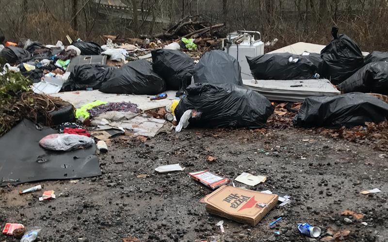 Garbage in this dump site in the Shuler Creek area of Polk County revealed the names of four Georgia residents. Those residents have been charged by U.S. Forest Service law enforcement officers and face federal penalties if convicted.