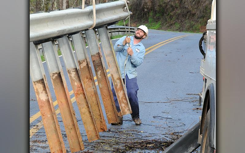 Nathan Heaton from Tri-State EMC works removing a section of guardrail from the side of Bullen Bap Road. The section was left unstable by a washout that occurred Thursday night, March 25, and had to be removed so Tri-State crews could work to stabalize a power pole that was also affected.