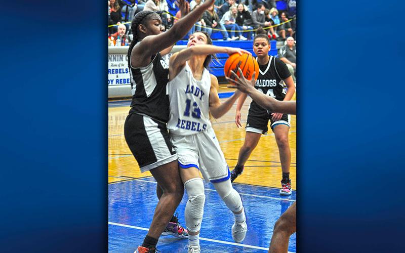 The Lady Rebels’ Becca Ledford fights for two of her 15 points against Butler’s Lady Bulldogs Saturday night. The Final Four game in the chase for the state championship was played in front of a packed house in the Fannin County High School gym.
