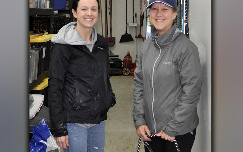 Fannin County Animal Control volunteers Jaime Pittman, left, and Donna Turek braved the cold and rain Friday morning, February 26, to walk and play with the dogs at the facility.
