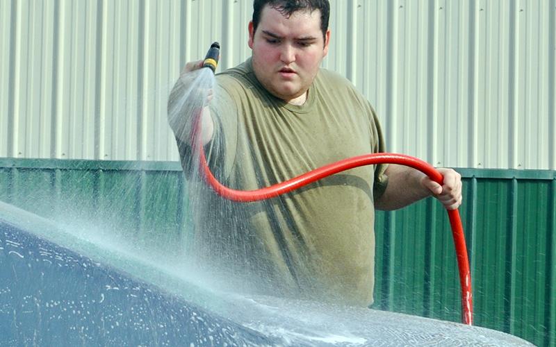 Mountain Area Christian Academy (MACA) Cadet Airman First Class Elijah Carroll sprays off a car during MACA’s JROCT car wash fundraiser Friday, March 12.