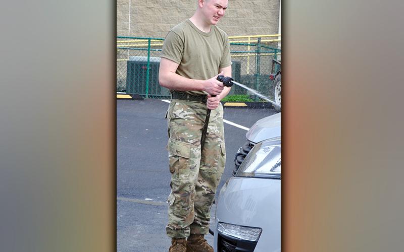 Mountain Area Christian Academy JROTC Cadet Airman First Class Dawson Long is shown rinsing off a car to raise money for a trip to Washington, D.C.