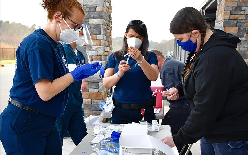 Fannin County EMA/Fire employees Trista Chancey, Tracy Padgett and Becky Huffman, shown from left, prep vaccines for school system employees.