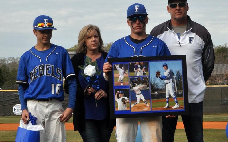 Tyler Fox was one of seven Fannin County seniors honored in between games at the Rebels double header against Chattooga Friday, April 23. Shown are from left, Carter Fox, brother; Dianne Fox, mother; Fox; and Todd Fox, father.