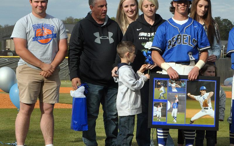 Caleb Postell was one of seven Fannin County seniors honored in between games at the Rebels double header against Chattooga Friday, April 23. Shown are from left front, Michael Postell, brother; Postell; middle, Matthew Postell, brother; John Postell, father; Stacy Postell, mother; Anna Postell, sister; Kaylin Postell, sister; and back, Kendall Postell, sister.