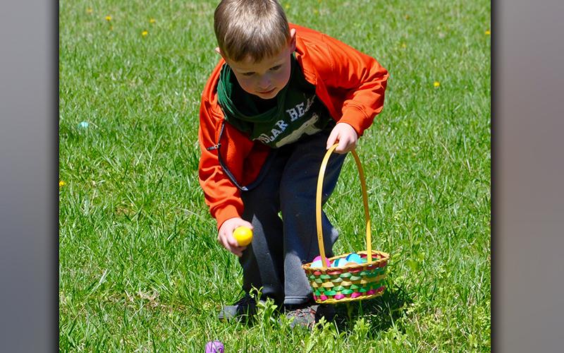 West Fannin Elementary School Pre-K student Gunnar Westphal picks up an Easter egg during the hunt orchestrated by the Fannin County High School Key Club.