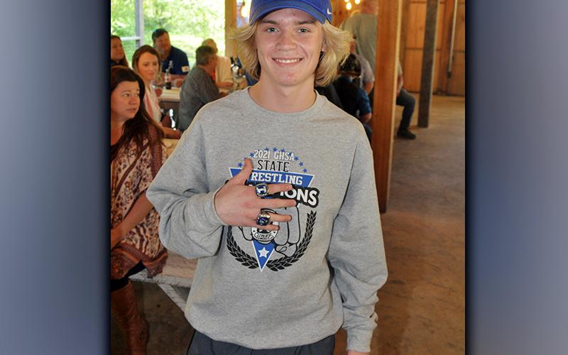Blake Summers smiles as he shows off his two state championship rings at the Rebels awards banquet and ring ceremony Thursday, May 6. Summers won the individual state championship in his weight class and helped the Rebels win the Georgia team championship. Summers also received the Most Outstanding Wrestler Award for finishing as 106-pound Area 8 AA Champion and AA State Champion.