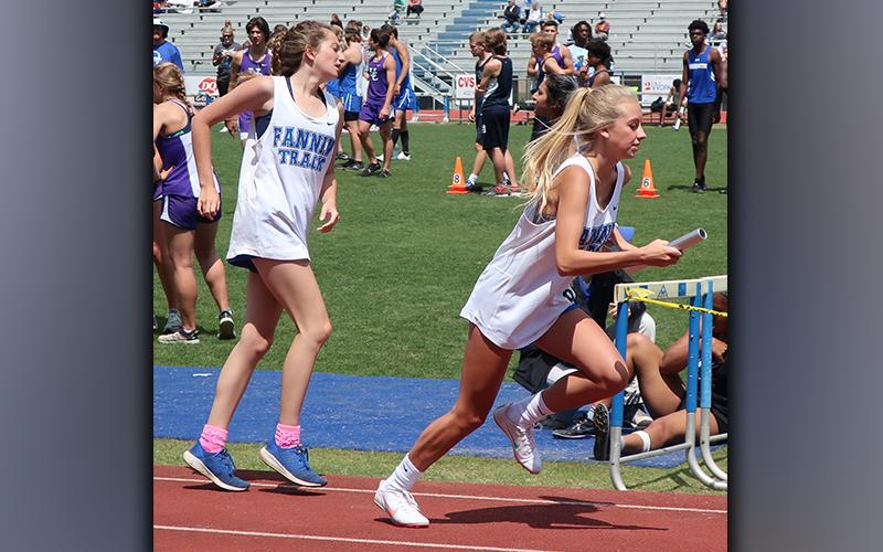Katie Thurman, left, third leg of the 4x800 Meter Relay team, passes the baton to anchor Carlee Holloway. The Lady Rebels 4x800 Meter Relay improved their time from Regions,12:09.23 to 11:59.22, to place eighth and advance to the state meet.