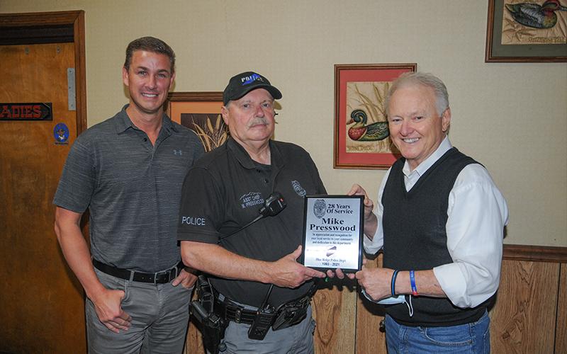 Assistant Chief Mike Presswood was presented a plaque by Chief Johnny Scearce, right, honoring his 28 years of service to the Blue Ridge Police Department. Nathan Fitts, left, who serves as police commissioner, also expressed his appreciation to Presswood.