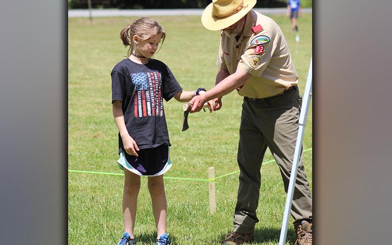 Boy Scouts of America Troop 32 Scoutmaster David Lewis instructs Morgan Kuykendall on how to perform the hatchet toss at Troop 32's Highland Games Saturday, May 1.