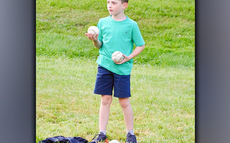West Fannin Elementary School third-grade student Bentley Cole helps fetch balls for the tossing event during field day Thursday, May 13.