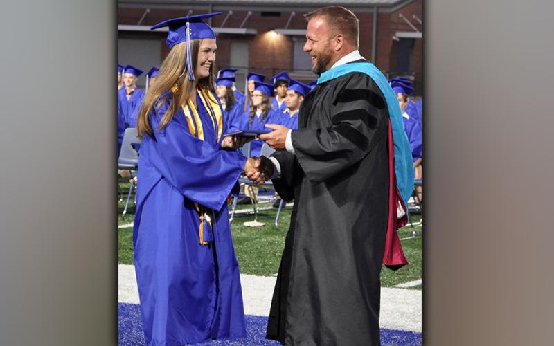 With the shake of hands, Isobella Dilbeck happily accepts her diploma from Fannin County High School 2021-22 Principal Dr. Scott Ramsey.