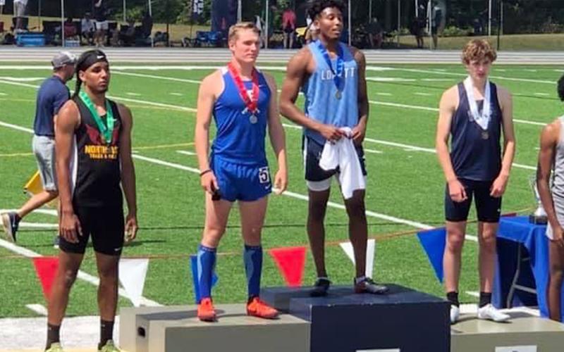Thomas Mercer, left, shows off his medal during the ceremony at the Track and Field State Championships Saturday, May 15. Mercer finished Runner- Up in the 300 Meter Hurdles with a time of 39.84.