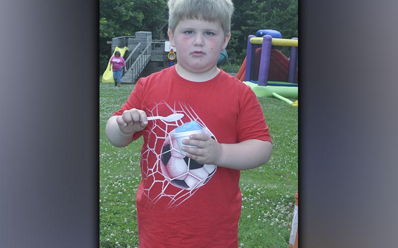 Ezra Johnson cools off with a snow cone during the carnival-themed Vacation Bible School at Pleasant Hill Baptist Church Wednesday, June 9.