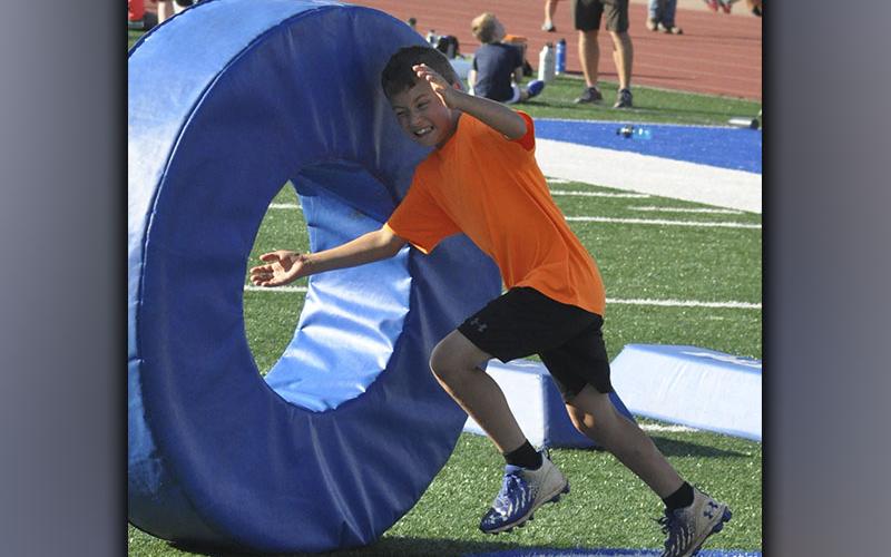Shawn Simmonds practices his tackling on a doughnut during the football camp at the Fannin County High School football field Wednesday, June 16.