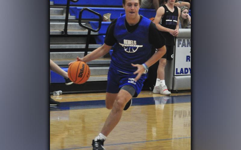 Luke Davenport edges out a defender for a score during the Rebels basketball scrimmage with Gilmer County Bobcats.