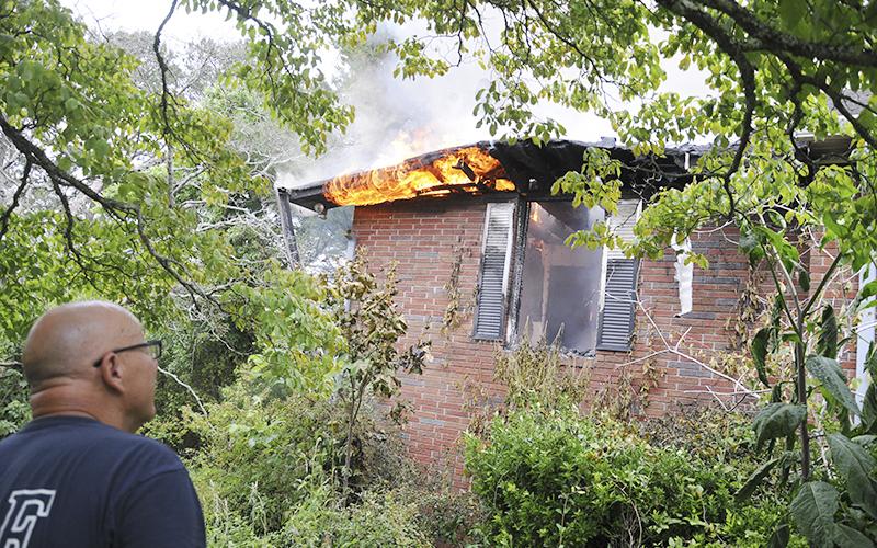 Fannin County Assistant Fire Chief Rob Ross watches as this fire at a residence off Blue Ridge Drive is being extinguished by firefighters on the inside.