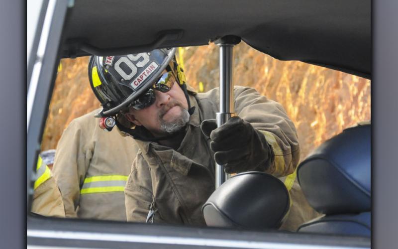 Fannin County Firefighter John Calvert uses a Hurst Ram to raise a roof on a wrecked car. This was one of the tools Fannin firefighters trained with during a refresher course on extricating patients from vehicles last week. Watching the effort is Fannin County Assistant Fire Chief Rob Ross.