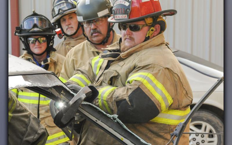 Carl Raymond, third from left, instructs Fannin County firefighters, from left, Virginia Jones, Randy Seers and Matthew “Big Money” Karry, in the latest extrication techniques to remove patients from wrecked vehicles. This was part of a refresher course taught by Raymond Wednesday, June 23, in Blue Ridge.