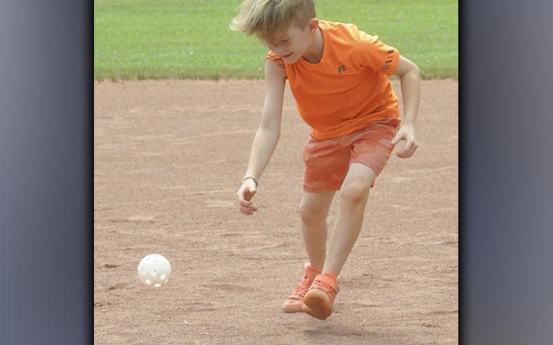 Coltlee Jackson picks up a wiffle ball and tries to get a runner out during the rec department’s Summer Camp Wednesday, June 9.