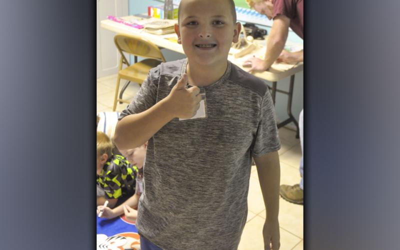 Izaiah Bradburn takes time out of coloring to smile for a photo during McCaysville Gospel Tabernacle’s Vacation Bible School Tuesday, July 13.