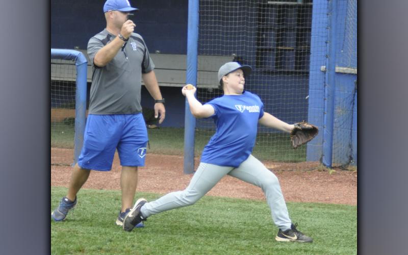 FCHS Head Baseball Coach Travis Stone times throw speed of Cayden Reece in a drill during the Pitchers and Catchers Camp Wednesday, July 7.