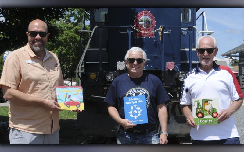 Kiwanis Club of Blue Ridge members Troy Shirbroun, Steven Miracle and club President Bill Echelberger hold examples of the books provided through Ferst Readers.