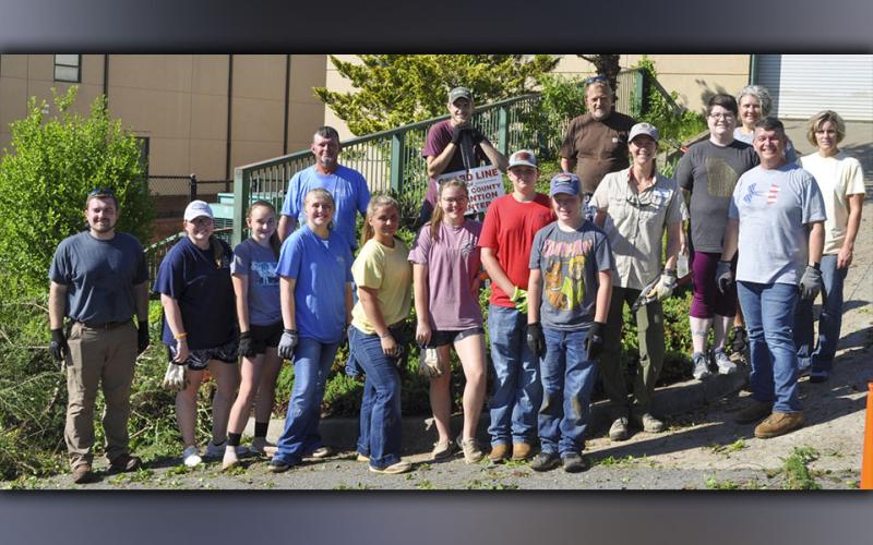 Members of the Fannin County community came together Wednesday, June 30, to clean up overgrown trees and brush outside the Fannin County Detention Center. Shown are, from left, Fannin County Middle School Agriculture teacher Seth Davis, Fannin County High School Agriculture teacher Emily Fellenbaum, FFA members Kaleighann Ware, Samantha Adkins, Zoe Pitman, Emmie Thomas, Jacob Williams and Castle Barnett; middle, University of Georgia County Extension Agent Ashley Hoppers, county Human Resources and Payroll