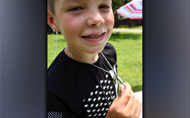 Clay Maddox, age 9, of Morganton, shows his necklace. A gift from his aunt, the necklace contains the ashes of his German Shepherd, Jake, an angel wing charm and Jake’s name.