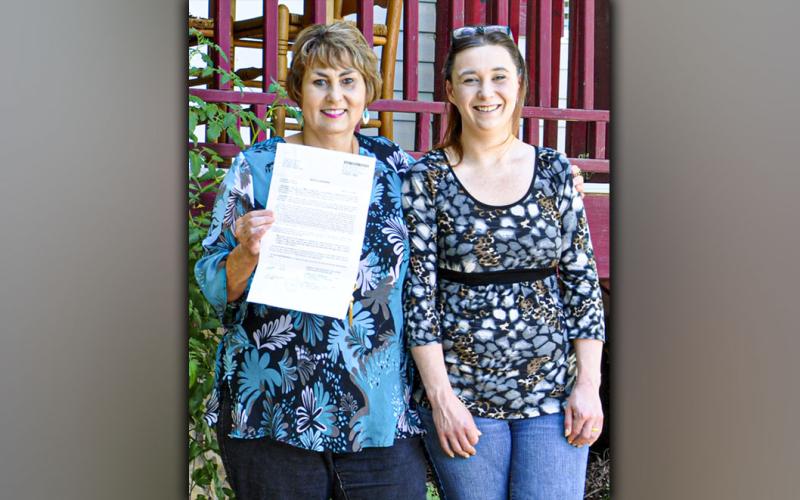 With the deed in hand, Gloria Ensley can say that her home is officially all hers. Gloria stands with her daughter, Ericia Almond.