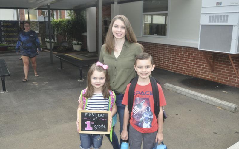 Carrie Anderson, middle, leads her kids Leia Anderson, left, and Alex Anderson into West Fannin Elementary School to start the first day of classes Friday, July 30.