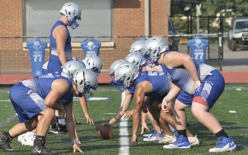 Offensive and defensive linemen line up and go through plays during the Rebels football practice Thursday, July 29.
