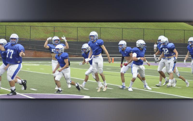 The Fannin County Rebel football team hypes up the crowd as they run out on the field at the start of their scrimmage game against Gilmer County Friday, August 6.