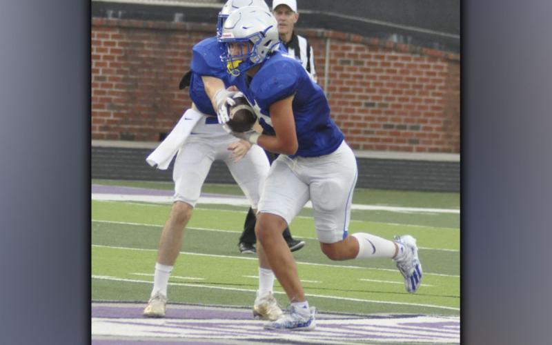 Quarterback David Mashburn hands the ball off to Cason Owensby during the Rebels scrimmage against Gilmer County Friday, August 6. Owensby had two touchdowns in the scrimmage.