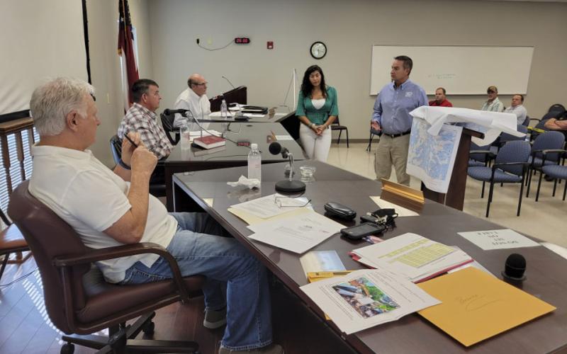 Fannin County commissioners Johnny Scearce, Chairman Jamie Hensely and Glenn Patterson, from left, listen as Frankie Rigdon, vice president of operations for ETC, discusses a broadband grant. Christie Gribble, second from right, executive director of the county’s Economic Development Authority presented the grant proposal.
