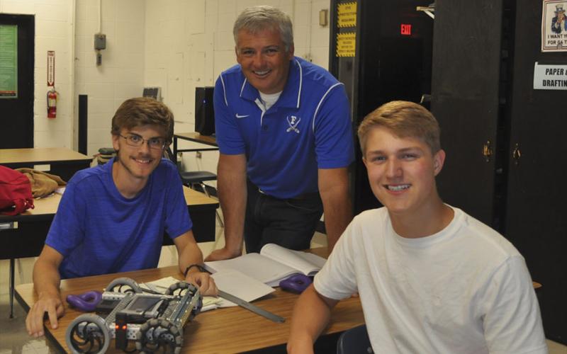 Engineering II students James Kyle, left, and Bryce Ware show off their completed robot to their teacher Bubba Gibbs at Fannin County High School Friday, August 6.