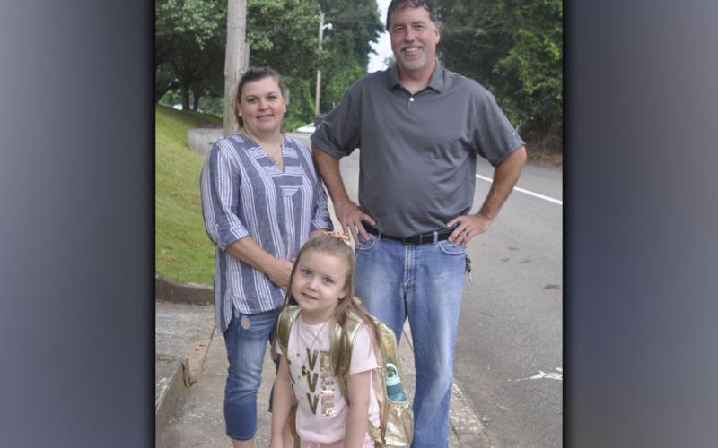 First grader Lainey Rhyne along with her parents Melissa and Richard Rhyne stop to pose for a picture on the first day of school at Blue Ridge Elementary School Friday, July 30.