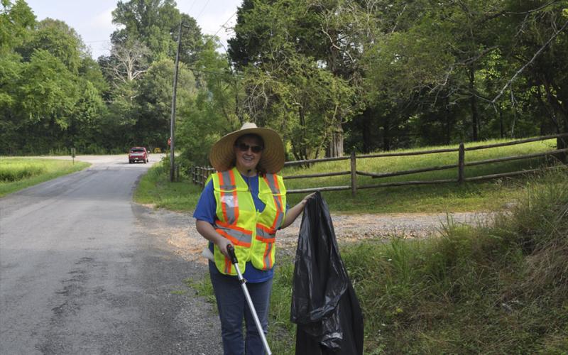 Dee Dee Deal helps to clean up trash along Reunion Road in Turtletown Saturday, July 24.