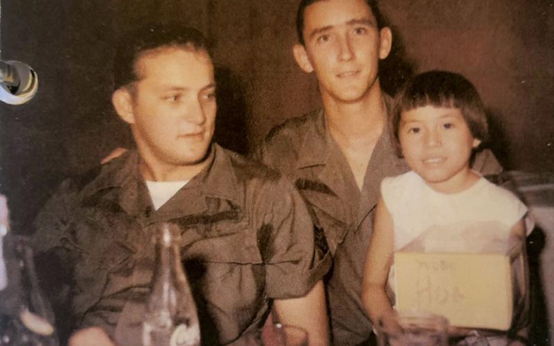 In Saigon, U.S. Air Force veteran Richard Crosley, left, is shown with a friend and a young, native girl named Hoa who he and his friends would give candy and treats to every time they knew they’d cross paths.