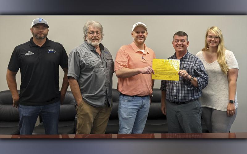Fannin County Board of Commission Chairman Jamie Hensley hands over a building permit to Habitat for Humanity of Fannin &amp; Gilmer Counties Executive Director Christopher Hall. The county donated the $250 permit for the organization’s latest home build planned in McCaysville. There in support are, from left, county building inspectors Jody Barfield and Keith Nicholson, Hall, Hensley and Administrative Assistant Candace Newton.