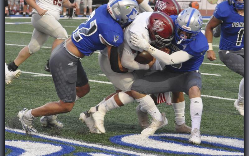 Cason Owensby (22) and Sawyer Moreland (15) bring down a Raider ball carrier during the Rebels football game against Southeast Whitfield County Friday, September 10.