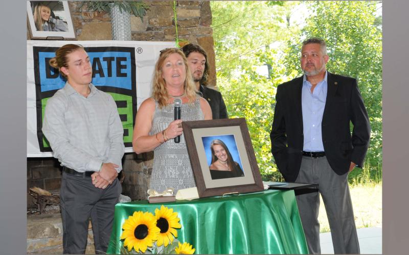Sydnie Grace Jones’ mother, Melinda, holding microphone, addressed a crowd gathered to remember her daughter and dedicate an intersection named in her honor.  Shown with Melinda are, from left, Sydnie’s brothers Andrew and Conner Jones, and her father, Anthony Jones.