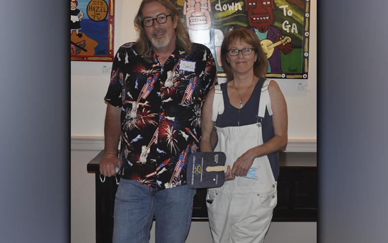 The Blue Ridge Mountains Arts Association held their opening reception for the Contemporary Southern Folk Art exhibit Saturday, September 4. Standing in front of some of his artwork during the reception is artist Sam Granger and Lorri Penn. The exhibit will be open until October 10.
