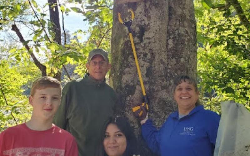 Blue Ridge Mountain Trout Unlimited Member Sandy Reinauer snapped this picture during Rivers Alive Saturday, September 25, while his group was cleaning the upper Toccoa River. A sign hidden from view urges, “If you must litter, stay home.” Shown with part of the trash they collected are,  from left, front row, University of North Georgia students David Britain and Macy Ruiz; and back row, Blue Ridge Mountain Trout Unlimited Member Bob Murrah and University of North Georgia Professor Anna Speessen.