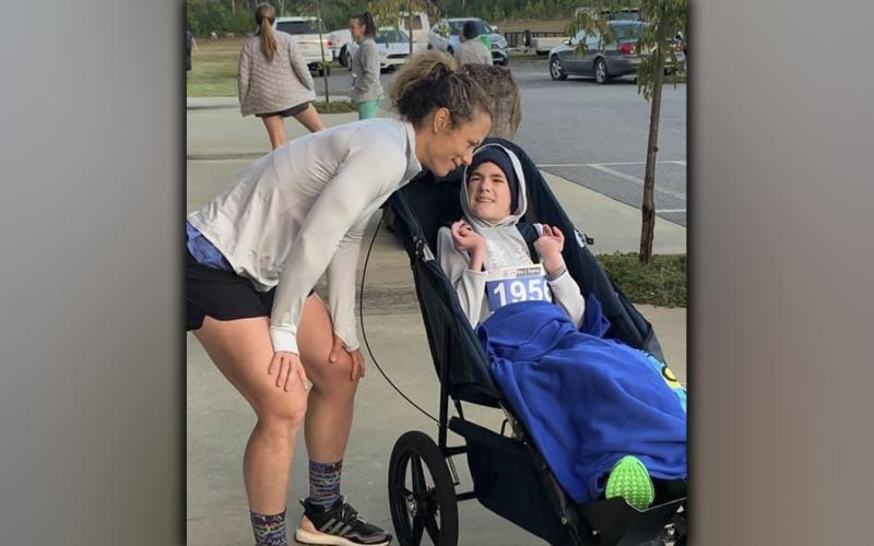 Brady Smith and his mother, Ashley Herendon, are all smiles after running in a community race.